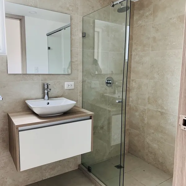 Baño remodelado con cabina de vidrio templado
